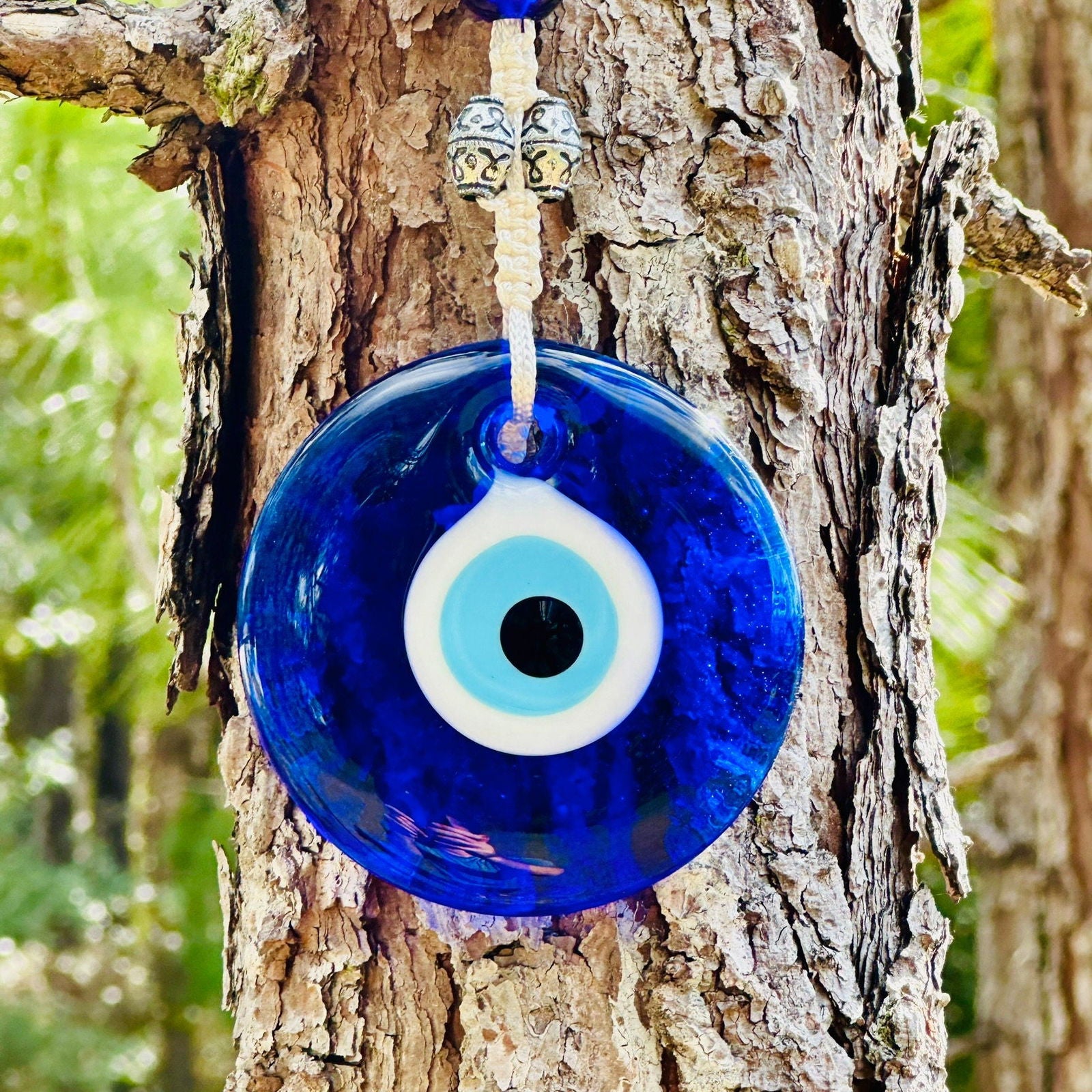 Blue evil eye glass charm wall hanging with white-and-black eye center