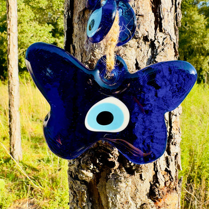Blue evil eye butterfly charm with large white eye on front, on macrame cord