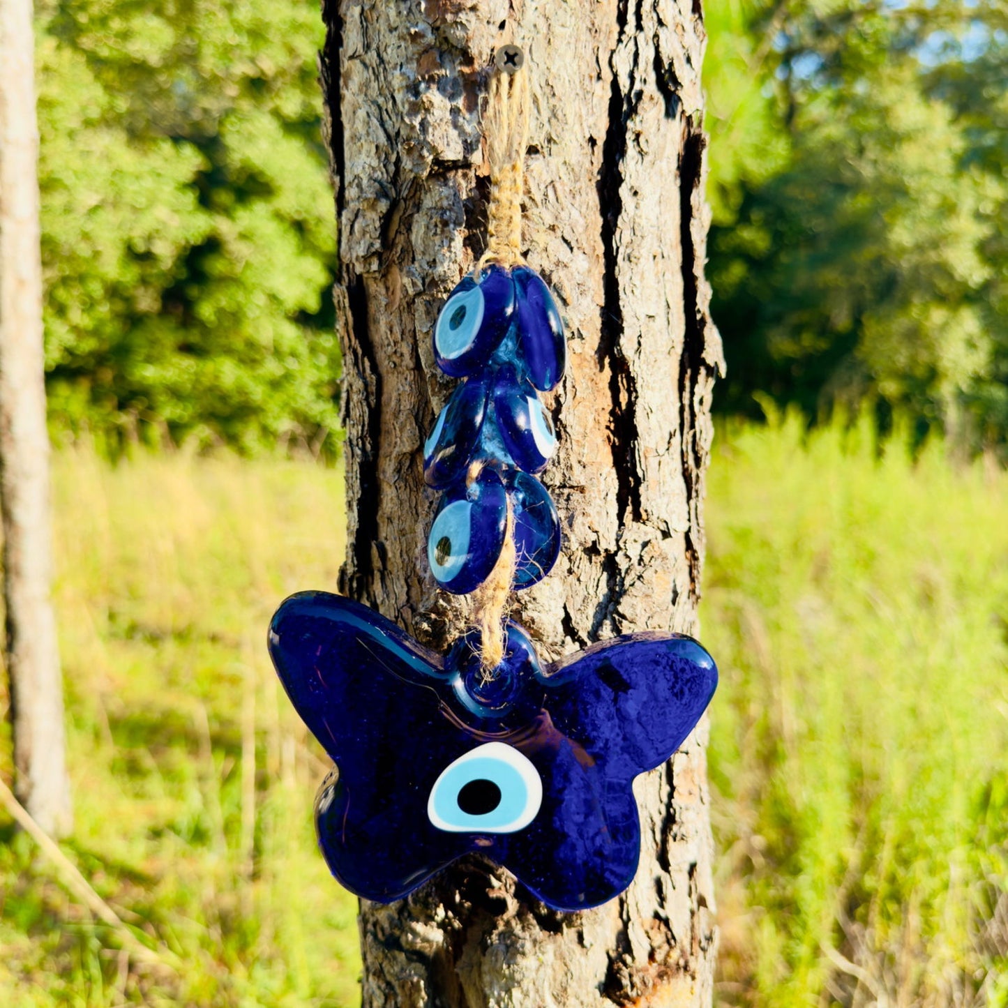 Blue evil eye butterfly amulet on macrame cord with multiple oval eyes