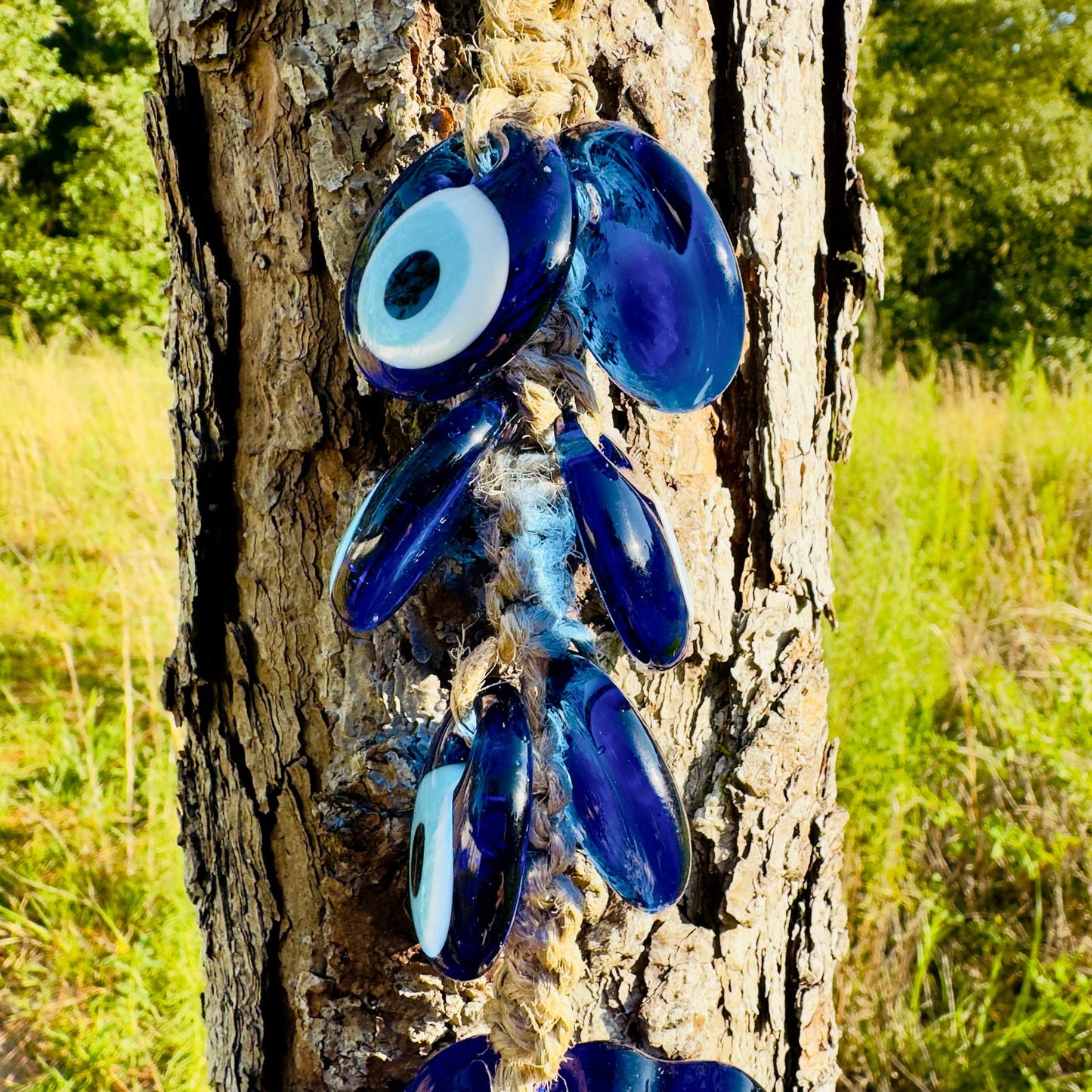 Blue evil-eye fish charm cluster with several eye beads and macrame string