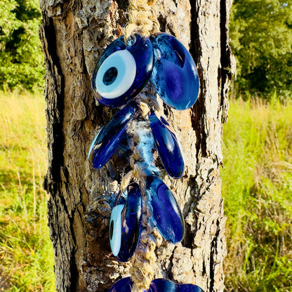 Blue evil-eye fish charm cluster with several eye beads and macrame string