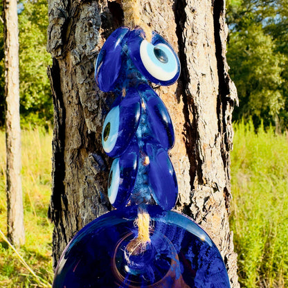 Blue hamsa hand wall hanging with large evil-eye disc and gold charm loop