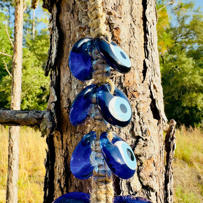Macrame evil eye wall hanging with multiple blue eye charms in a vertical row