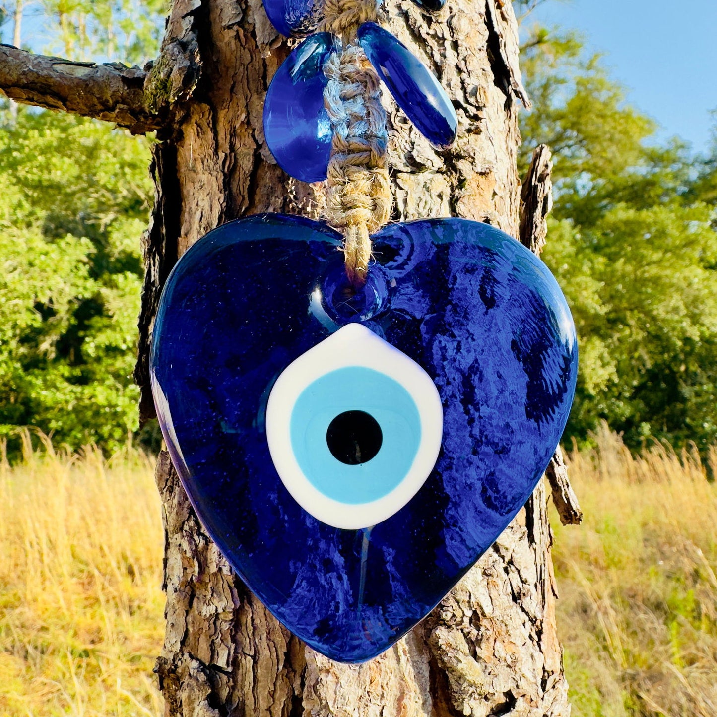 Blue heart-shaped evil eye ornament on macrame cord with white eye centers