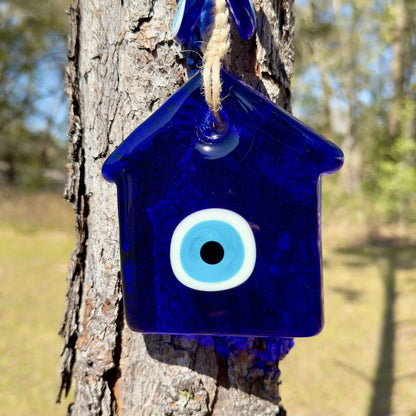 Blue glass house amulet wall hanging with large white evil eye, hanging cord.