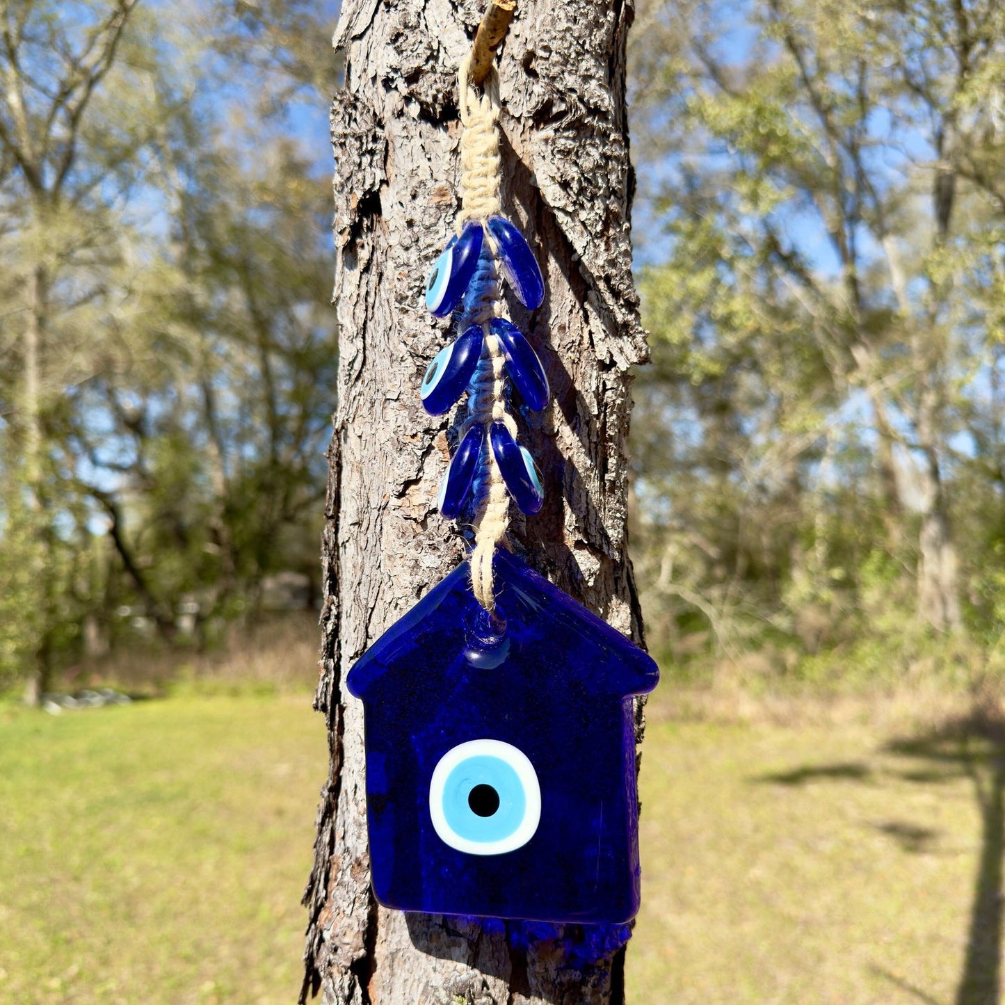 Blue evil eye house wall hanging with macrame cord and white eye charm.